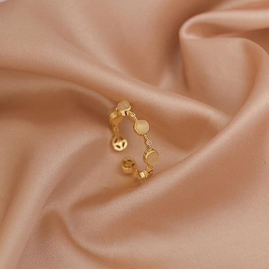 エレガントな調整可能なオキュラスリング、上品なゴールドに輝く白い石付き