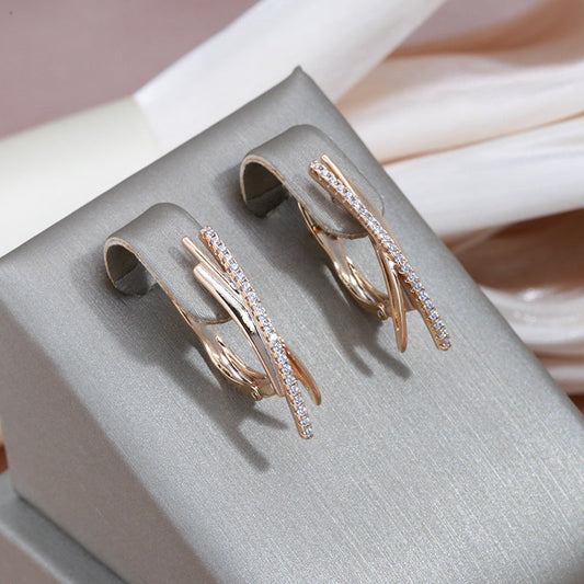 エレガントなゴールドのクロスデザインのダイヤモンドが輝くイヤリング